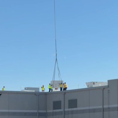 Helicopter placing rooftop HVAC unit during commercial HVAC installation